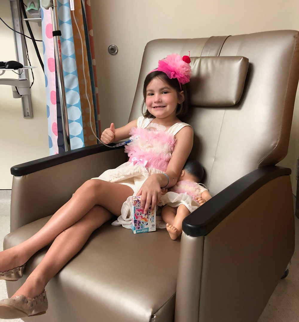 Patient Hannah gives a thumbs up while getting her treatment