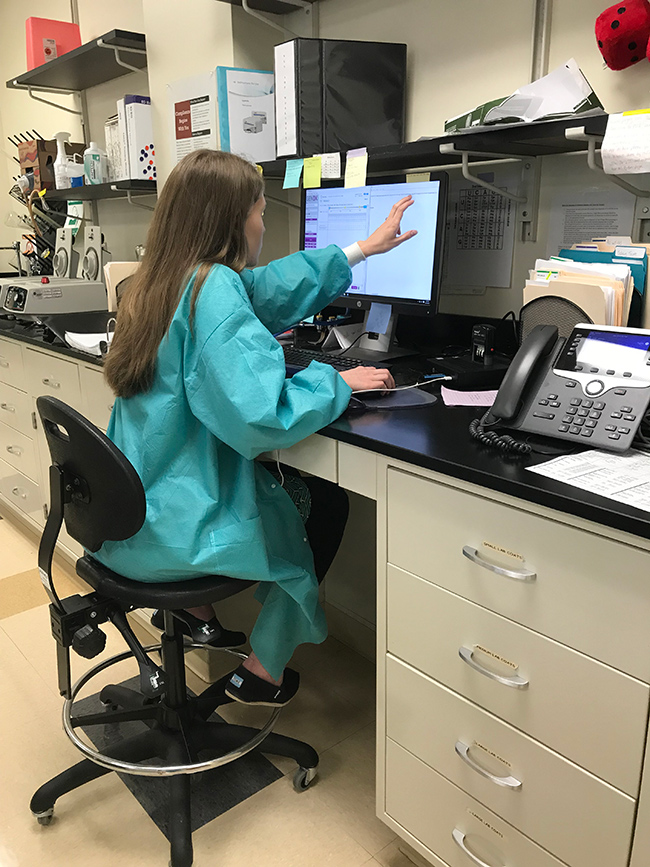 Female lab tech in front of a computer.