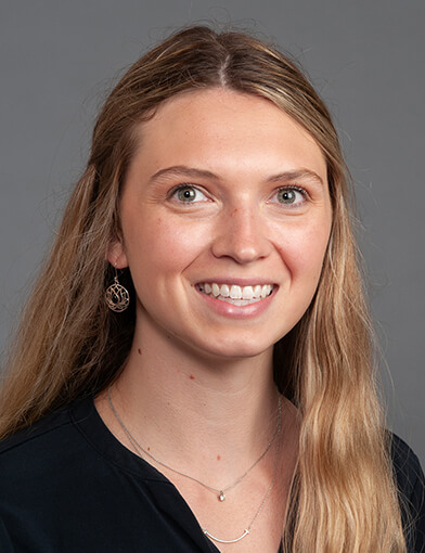 A young woman with long hair smiling at the camera.