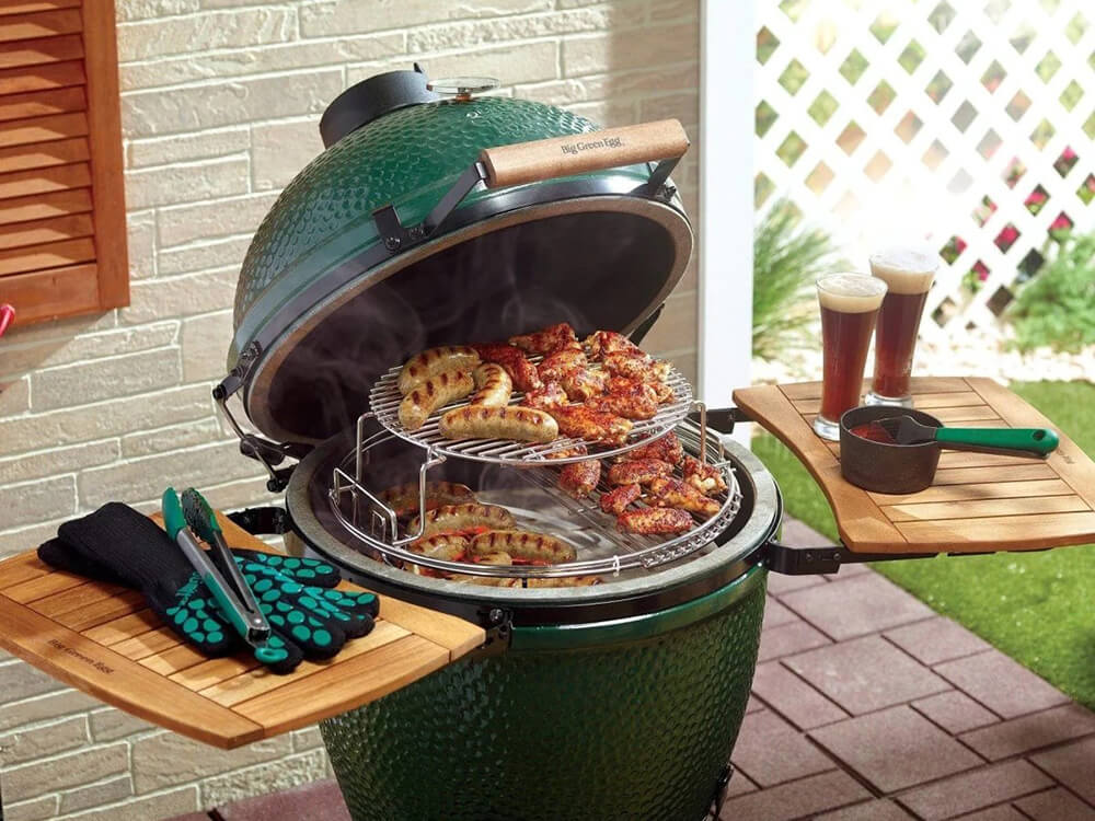A green grill cooking a collection of different foods.