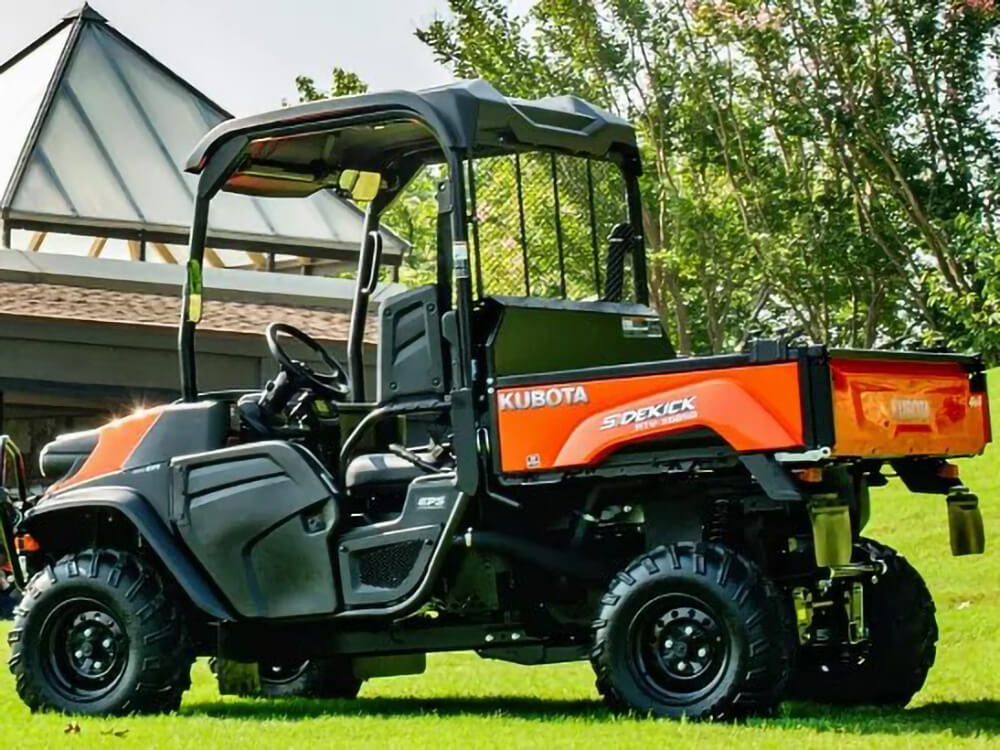 An orange and black RTV parked in a grassy field.